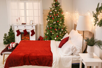 Interior of bedroom with glowing lights, Christmas trees and fireplace