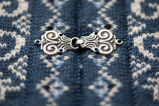 closeup macro of buckle on traditional nordic woolen blue woolen sweater pattern