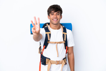 Young mountaineer woman with a big backpack over isolated white background happy and counting three with fingers