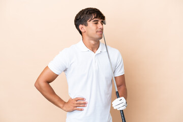 Young golfer player man isolated on ocher background suffering from backache for having made an...