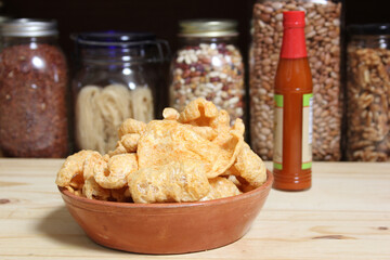 Fried Pork Skins With Hot Sauce in Rustic Kitchen