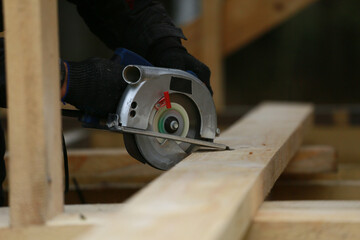 carpenter cutting wood with a saw