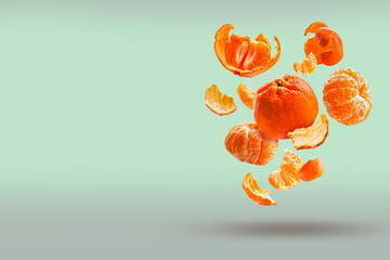 Tangerines fall into the air, isolated on a pale green background with space for text. Food levitation, weightlessness concept, weightlessness.
