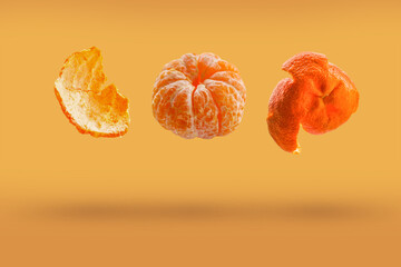 Tangerines are falling into the air, isolated on an orange background with space for text. Food...