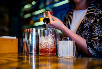 woman hand bartender making negroni cocktail in bar