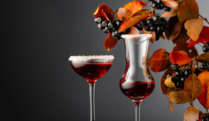 Fresh berries of chokeberry and glasses with juice or syrup.
