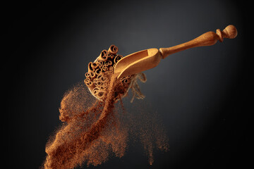 Cinnamon powder is poured out of the wooden spoon.