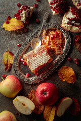  Honeycomb, apples, and pomegranate on an old stone table.