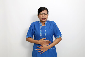 Young asian woman standing while holding her belly. Stomach ache concept. Isolated on white background