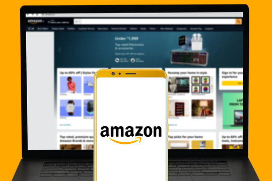 MADURAI, INDIA, 12TH NOVEMBER 2022: Amazon company logo displayed in mobile and their website blurred in computer screen. illustrative editorial. 