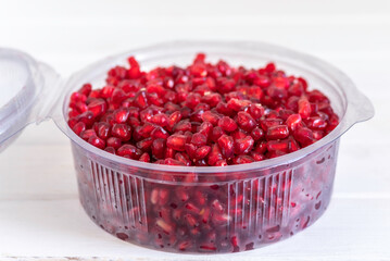 Pomegranate seeds in plastic box.