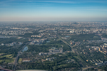 Fototapeta premium Aerial view photo from airplane of city and clear sky. aerial photo of large city from an airplane window. view of city of Moscow through window from plane