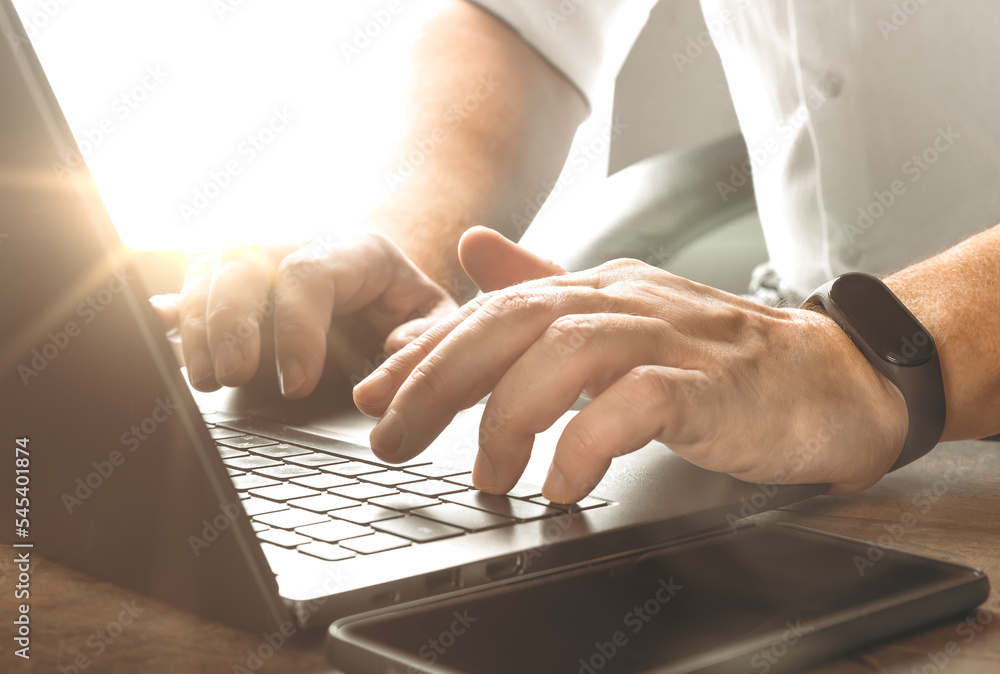 Poster close up businessman working on modern office. man sitting wood table and using contemporary noteboo