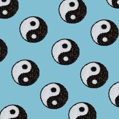 Pattern of the worldwide known Chinese symbol of balance ying and yang on blue background made of salt and pepper - obrazy, fototapety, plakaty