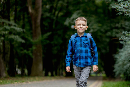 Portrait of a first grader with a backpack. The boy goes to school