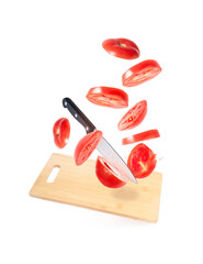 Knife cuts tomatoes flying in the air - cooking concept - promotional image