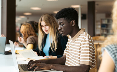 Young people studying together in university library - School education concept