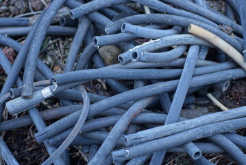 garbage from old black gray plastic pieces of tubes on the ground on the street