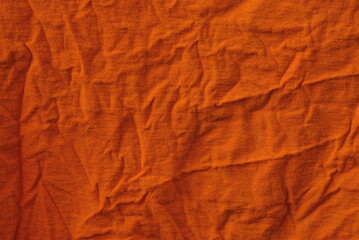 bright orange fabric background from a piece of crumpled clothes