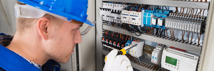 Male Electrician Examining Fusebox