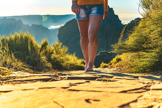 Legs of an athletic woman walking barefoot in the evening sun on Pico do Ariero on a super beautiful hiking trail. Verade do Pico Ruivo, Madeira Island, Portugal, Europe.