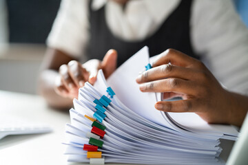 Clerk With Stacked Tax Files And Documents