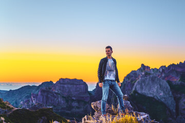 Man in leather jacket enjoying the scenic evening atmosphere of mountain terrain in the valley on Pico do Ariero. Verade do Pico Ruivo, Madeira Island, Portugal, Europe.
