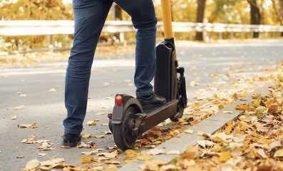 Close up view of eletric scooter that is riding by a man on the road