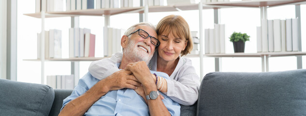 Happy senior couple family, caucasians mature, adult lover and retired man, woman embracing, hugging make romantic, empathy on sofa, couch at home together. Smile, husband and his wife lifestyle.