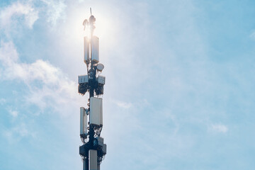 LTE radio network communication equipment with wireless modules and smart antennas mounted on metal on clouds sky background. Telecommunication tower of 4G and 5G cellular. Macro base station. - obrazy, fototapety, plakaty