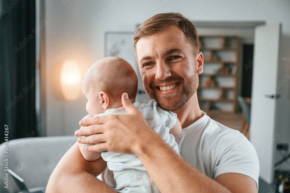 Sticker Standing with baby in hands. Father with toddler is at home, taking care of his son