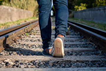 Hombre caminando en solitario por las vías del tren - obrazy, fototapety, plakaty