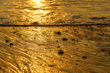 Textured beach sand during golden sunset.