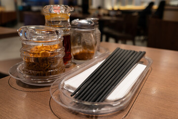 Close-up view of the various type of seasonings ,chopsticks and tissues on the restaurant table for self-service.