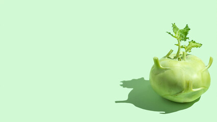 Kohlrabi on green background with copy space.