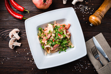 Georgian food vegetable salad Sazaphulo with nut dressing: tomatoes, cucumbers, sweet peppers, garlic, onions, walnuts, cilantro on a plate.