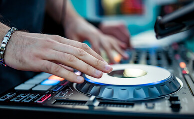 DJ Hands creating and regulating music on dj console mixer in concert