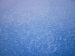 Obraz premium background frost on metal with shallow depth of field,winter background with ice crystals on blue surface with blurred background