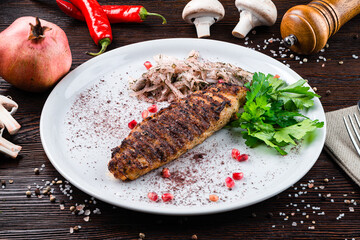 Chicken kebab, grilled chopped chicken fillet with spices and herbs, pomegranate seeds, onion.