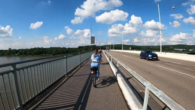 A pathway along Rhein River, where people ride their bikes over the bike lane and take a walk over the sidewalk together