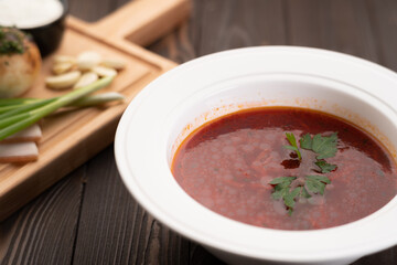 Borscht. Traditional Ukrainian dish in a plate on a wooden background. Tasty beetroot soup in bowl