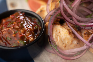 Kebabs background - grilled meat with ketchup, kebab with vegetables on blue plate. Bbq restaurant menu. Macro shot