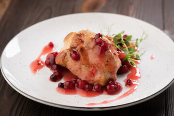 Grilled chicken fillet with cranberry sauce on white plate, close-up.