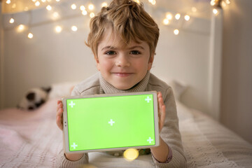 Christmas New Year gift concept. Cute child show green screen horizontal chroma key device tablet...