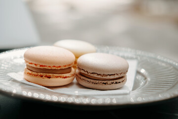 Close up shot of three delicate macaroons outdoors on a terrace table.