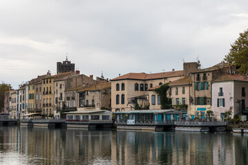 Fototapeta na wymiar Façade des immeubles et maisons au bord du fleuve Hérault dans le centre historique d'Agde