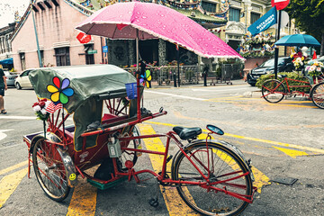 Traditional mode of transportation for tourists in Malaysia, tricycle parked on the street in...