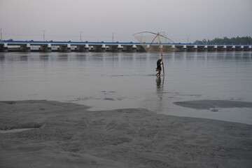 Man fishing in the river by net