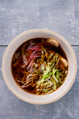 Asian soup with beef, iceberg lettuce, noodles in a bowl