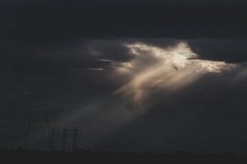 Beautiful shot of the sun shining through clouds in a dark sky